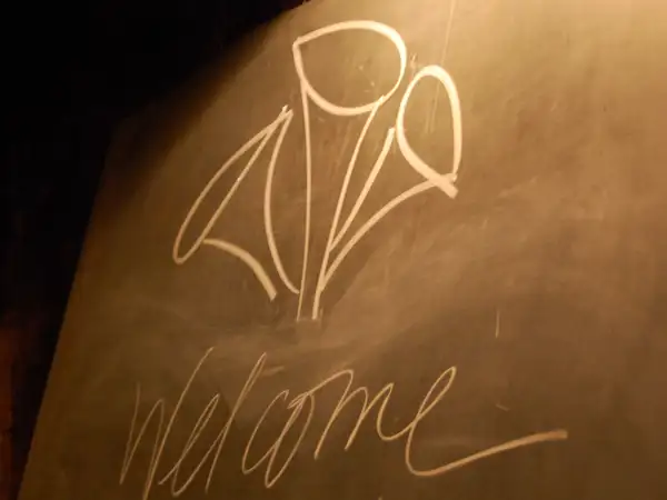 A chalkboard welcoming guests with the Black Trumpet logo. 